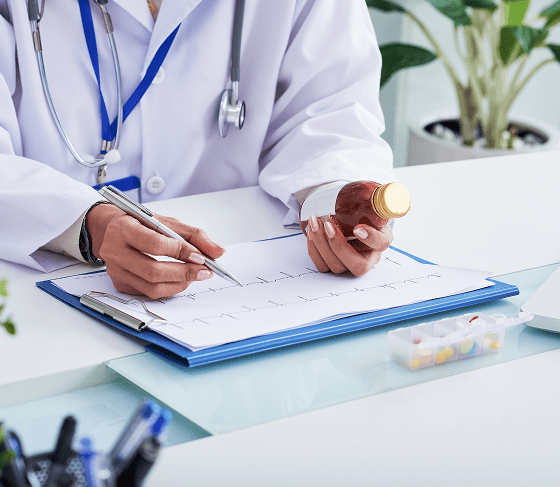 Doctor reviewing medication and writing notes, medication management psychiatry