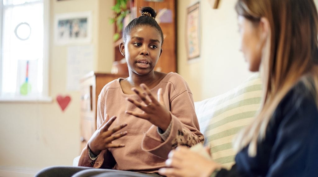 Woman discussing sleep disorder treatment with a therapist in an office setting.