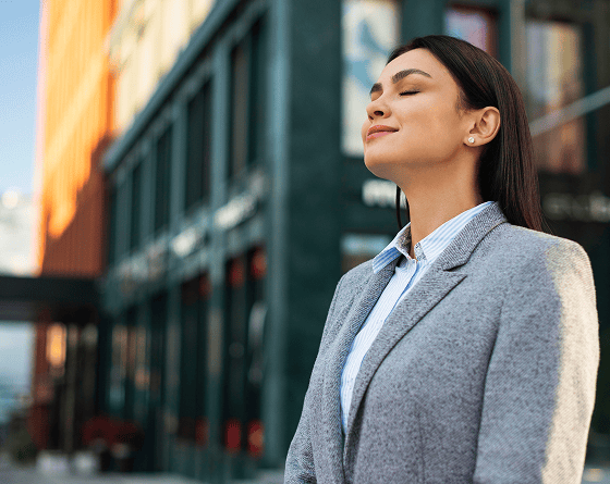 Woman in business attire enjoying fresh air, representing individual therapy benefits.